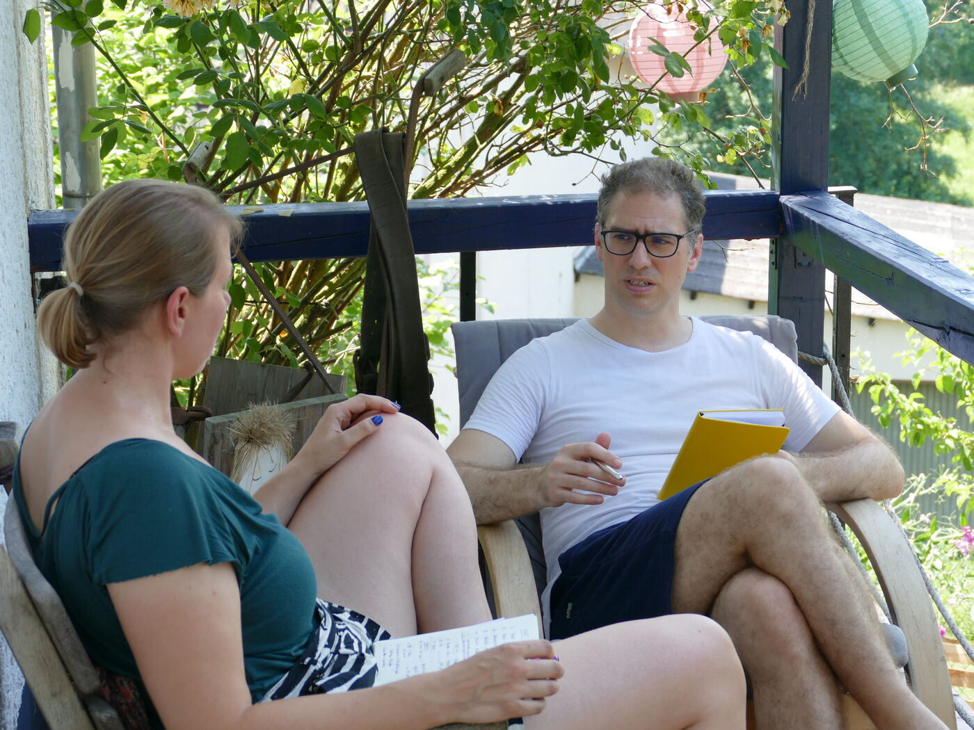 Zwei Teilnehmende im Gespräch auf dem Balkon des Seminarhofs